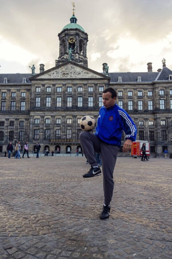 Airnesto Freestyle demonstreert voetbaltrucs tijdens een workshop, jongeren oefenen de basis van voetbalkunsten.